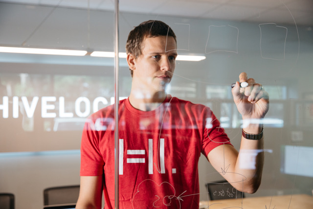 Hivelocity employee writing code on a board