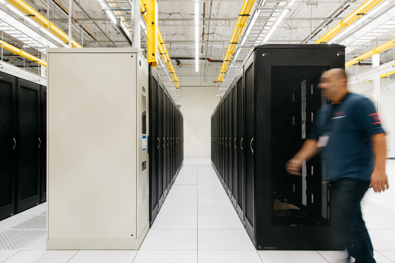 A Hivelocity employee walking past a row of server cabinets within one of our data centers