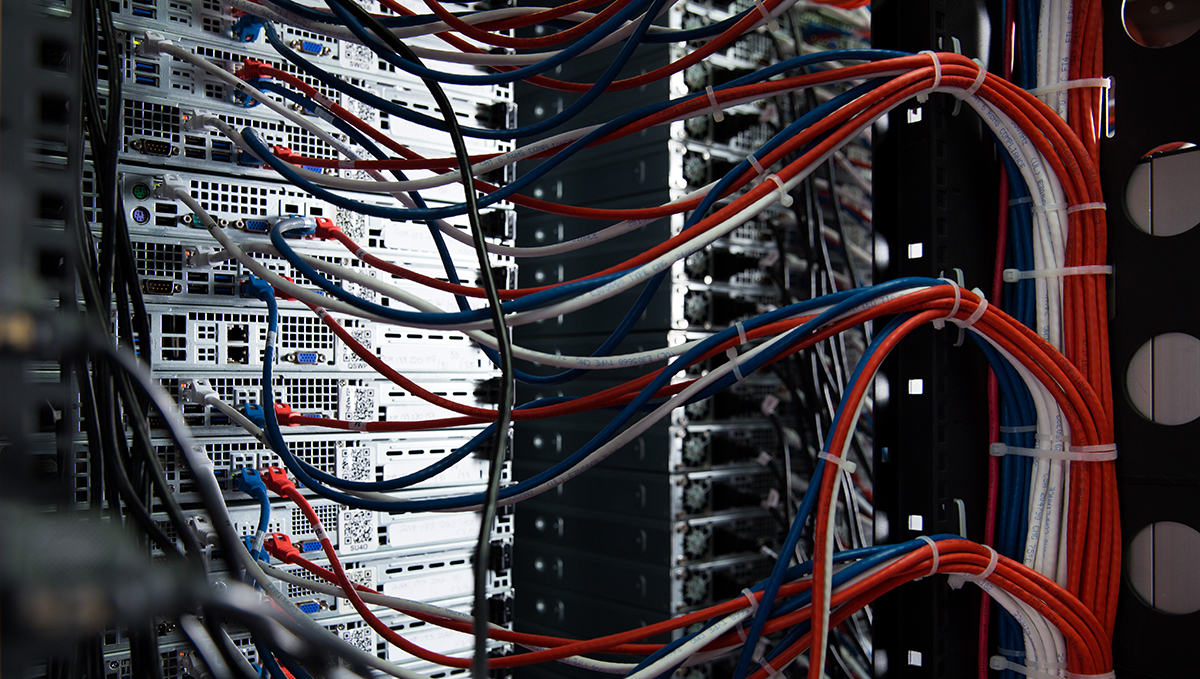 Back end of server stack, showing various cables being interwoven together